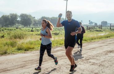 A group of runners enjoys a vibrant morning jog on a rural dirt road.